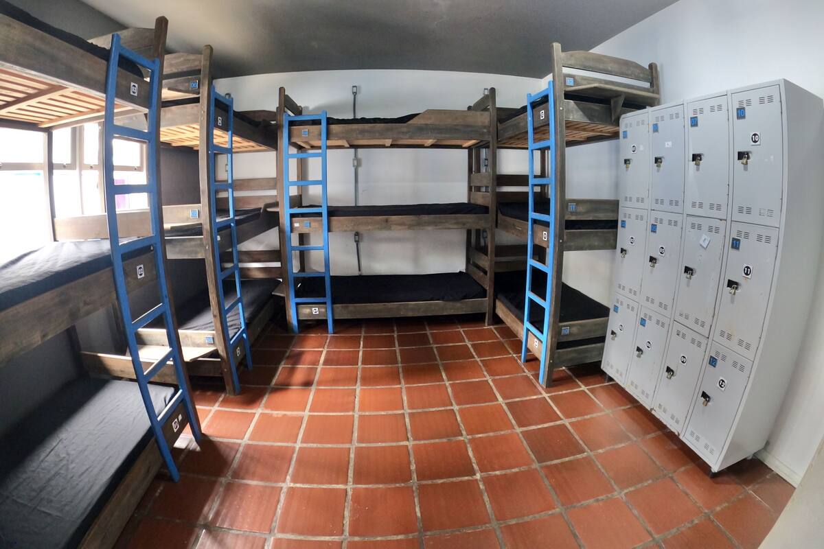 Una camera del dormitorio con letti a castello, una scala e una fila di armadietti.