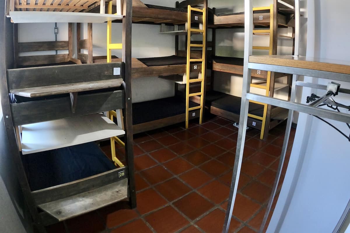 Una stanza con un letto a castello, una scala, una scrivania e una sedia.