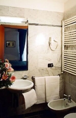 Ein Badezimmer mit Waschbecken, Bidet und Spiegel.