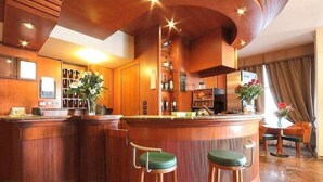 A bar area with wooden furniture, a counter, and stools. - Arcadia (Florence)