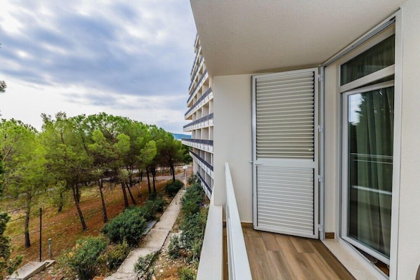 A balcony with a view of trees and a building.