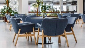 A modern dining area with round tables and blue upholstered chairs. - Hotel Medena Block A (Seget)