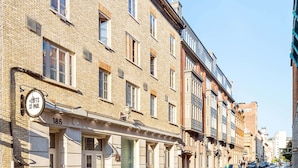 Une rangée de bâtiments historiques en briques, avec une rue devant.
