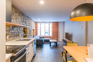 Una cocina moderna con salpicadero de piedra, una zona de comedor con mesa y sillas de madera, y un ventanal con vistas.