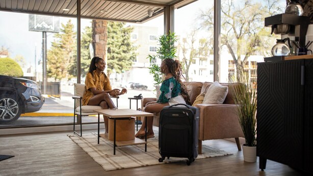 Un área de estar interior moderna con un sofá, una mesa y una cafetera.