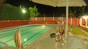 A swimming pool with a glass table and chairs, surrounded by a brick wall and a fence. - Caraná (Montenegro)