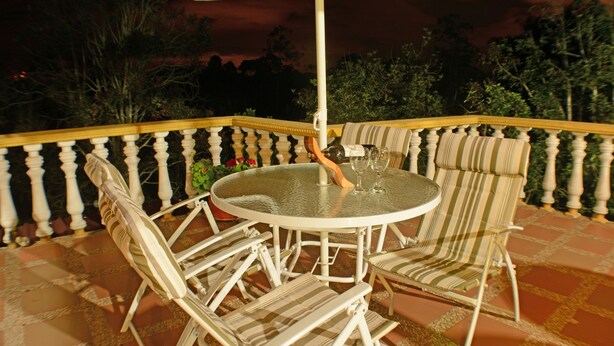 An outdoor patio with a round table and four chairs, surrounded by a white balustrade. - Caraná (Montenegro)