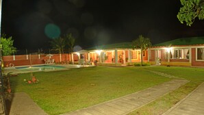 A well-lit outdoor area with a swimming pool, lounge chairs, and a covered seating area. - Caraná (Montenegro)