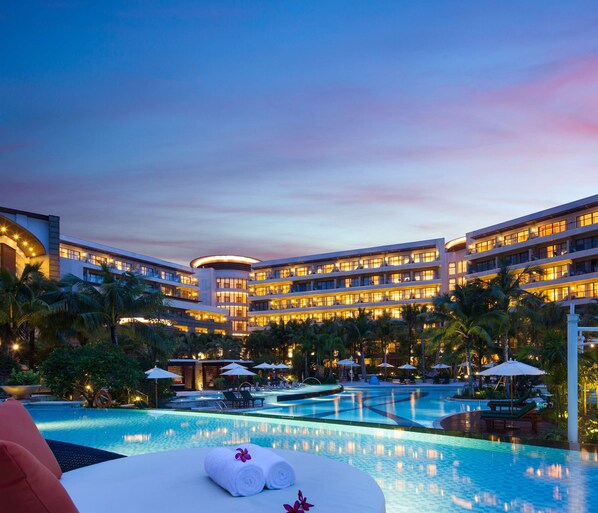 A hotel with a large pool, multiple balconies, and palm trees. - Thousand Cranes Sanya Yazhou Bay Int'l Exchange Centre  (Sanya)