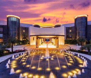 A modern hotel entrance with a fountain, a covered walkway, and two cylindrical towers. - Thousand Cranes Sanya Yazhou Bay Int'l Exchange Centre  (Sanya)