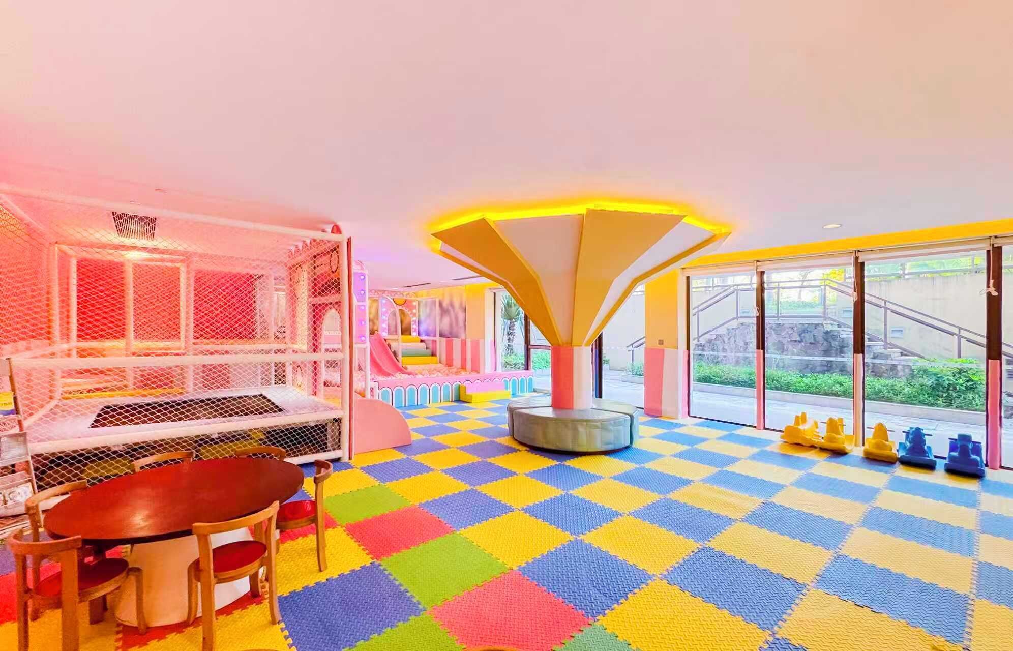 Ein hell erleuchteter Indoor-Spielbereich mit Schachbrettmuster-Boden, einem Spielbereich und einer Rutsche.