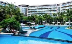 A hotel with a large swimming pool, multiple lounge areas, and lush greenery. - Thousand Cranes Sanya Yazhou Bay Int'l Exchange Centre  (Sanya)