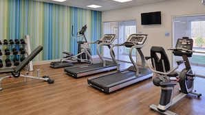 A gym with treadmills, dumbbells, and a TV on the wall. - Holiday Inn Express & Suites Southgate - Detroit Area by IHG (Southgate)