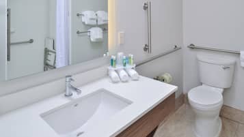 A modern bathroom with a sink, mirror, and toilet.