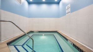 Una piscina con un cartel que indica una capacidad de spa para 7 personas.