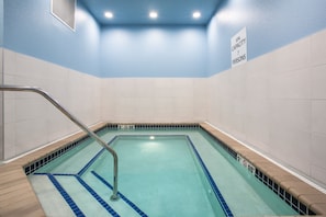 Una piscina con un cartel que indica una capacidad de spa para 7 personas.