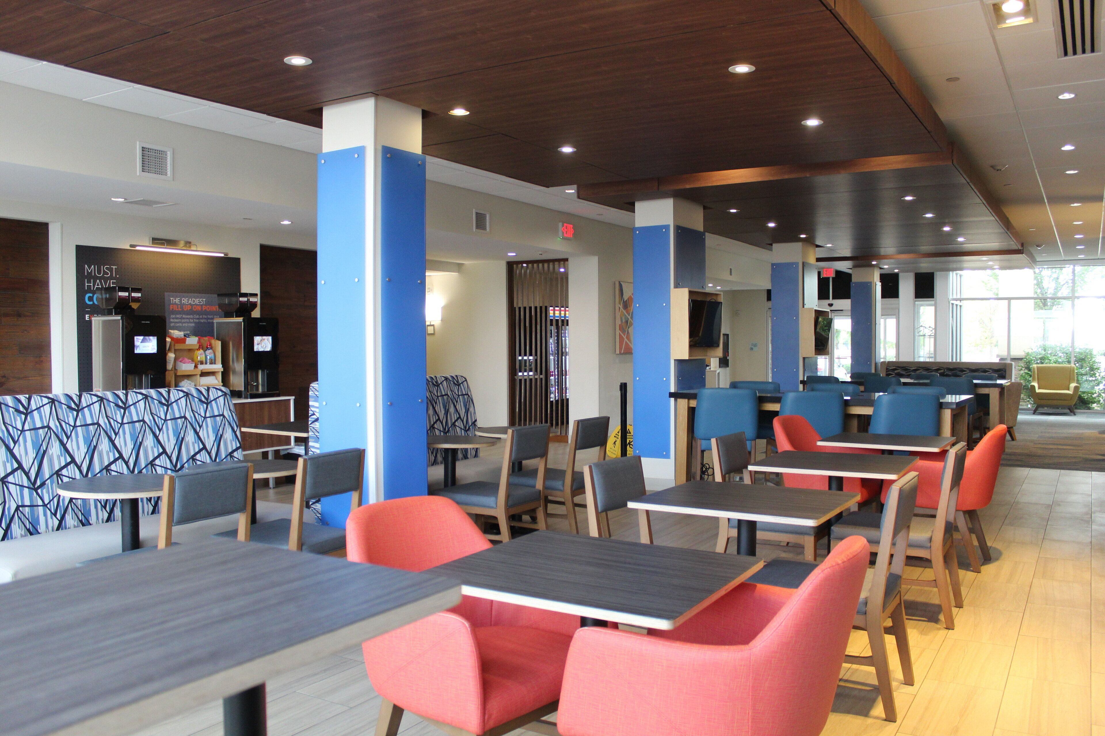 A modern restaurant with booths and tables, wooden ceiling, and blue accents.