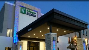 Un bâtiment de la chaîne Holiday Inn Express, doté d’une architecture moderne, avec une enseigne bien visible et un espace d’entrée abrité.