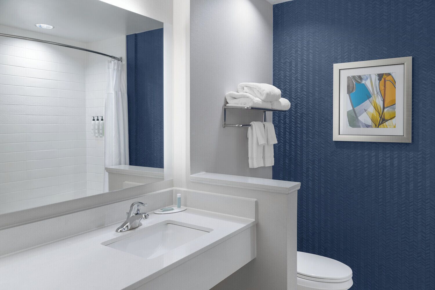 Een moderne badkamer met een wit wastafelmeubel, spiegel en blauwe wanden.