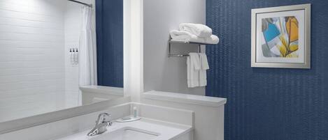 Een moderne badkamer met een wit wastafelmeubel, spiegel en blauwe wanden.