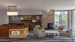 A modern lobby with a reception desk, seating area, and a stone fireplace. - Fairfield Inn & Suites by Marriott Atlanta Acworth (Acworth)