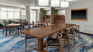 A conference room with a long table, chairs, and a kitchen area in the background. - Fairfield Inn & Suites by Marriott Atlanta Acworth (Acworth)