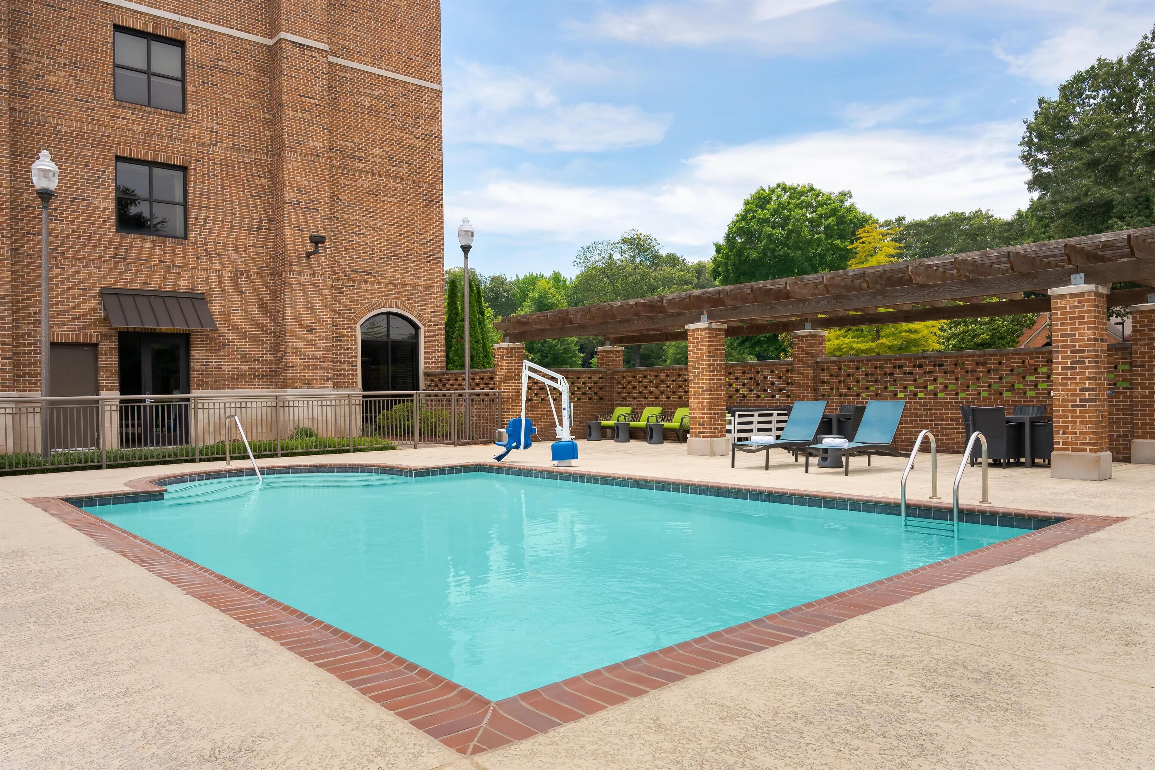 Una piscina al aire libre de temporada, sillones reclinables de piscina