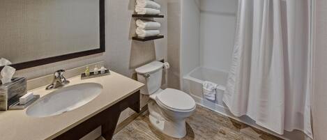 A bathroom with a sink, toilet, and shower curtain.