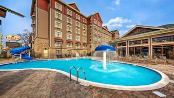 Een seizoensgebonden buitenzwembad, ligstoelen bij het zwembad