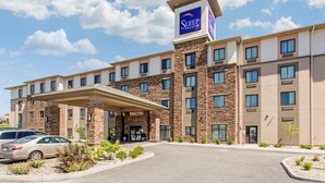 A Sleep Inn & Suites hotel with a stone facade, multiple balconies, and a covered entrance. - Sleep Inn & Suites Middletown - Goshen (Middletown)