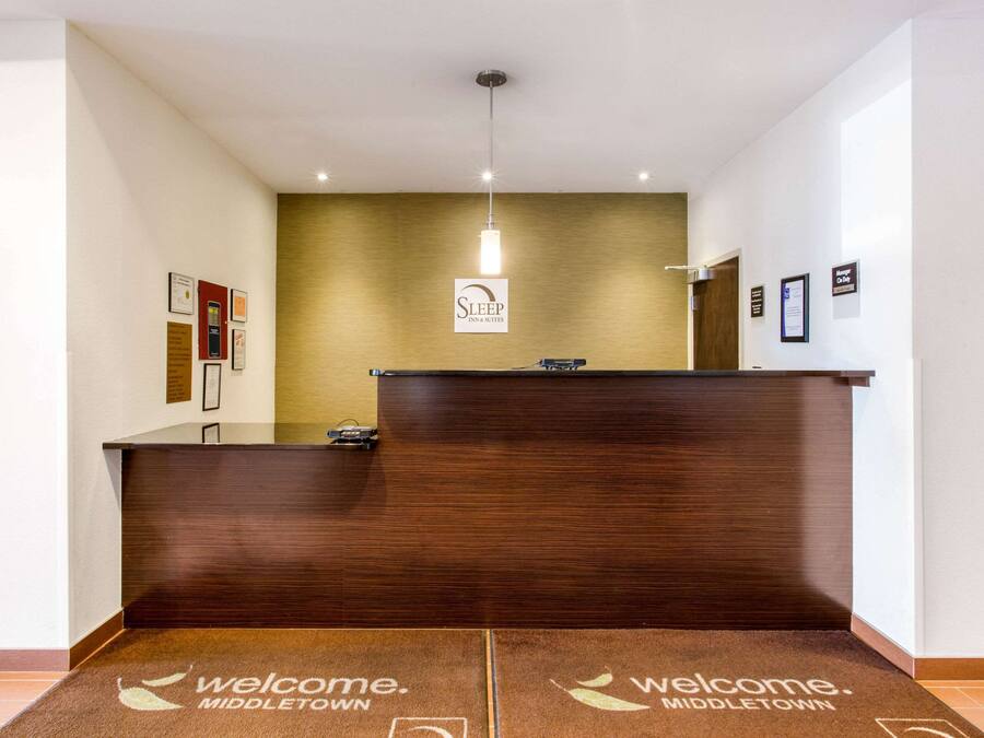 Un comptoir d’accueil avec un tapis sur lequel est écrit « Bienvenue à Middletown », une enseigne au-dessus du comptoir et des certificats encadrés accrochés au mur.