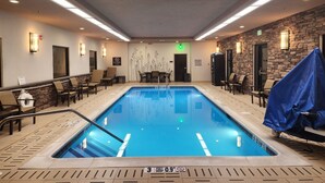 An indoor swimming pool with lounge chairs and a stone wall. - Sleep Inn & Suites Middletown - Goshen (Middletown)