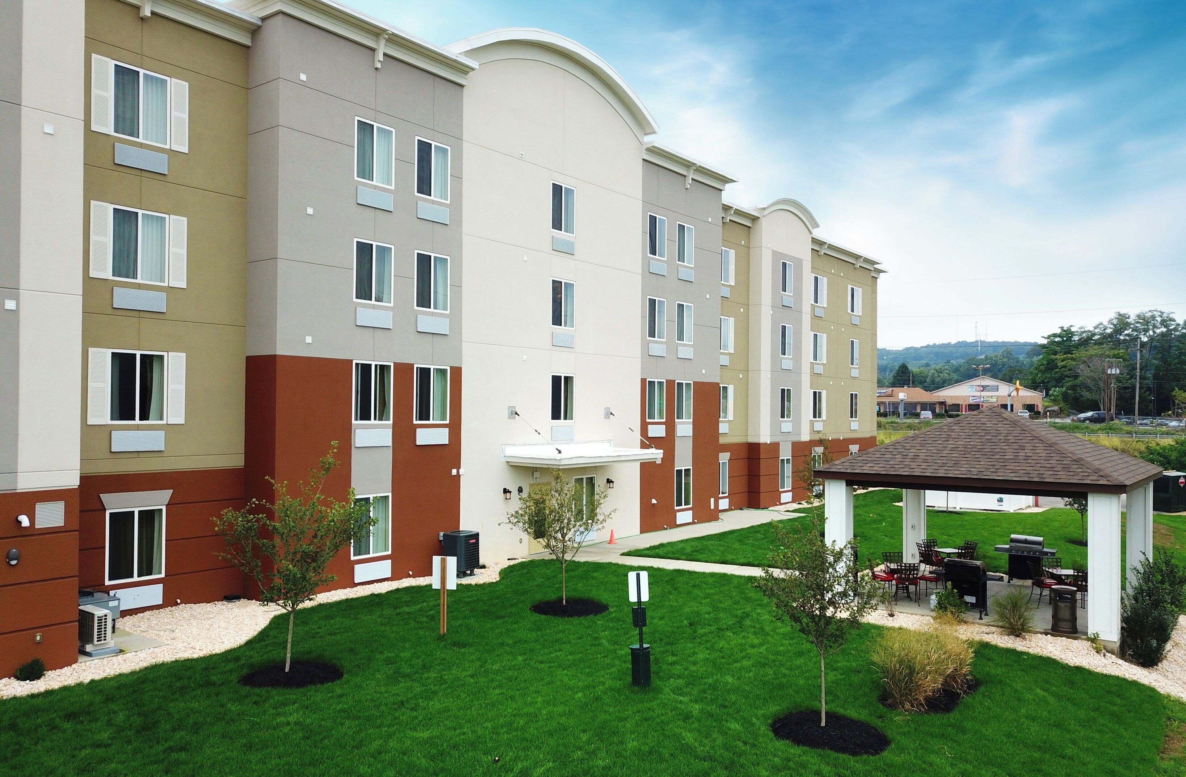 A multi-story hotel with a central courtyard, outdoor seating area, and a covered gazebo.
