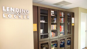A lending locker area with bookshelves and a sign indicating the availability of utensils at the front desk. - Candlewood Suites York by IHG (York)