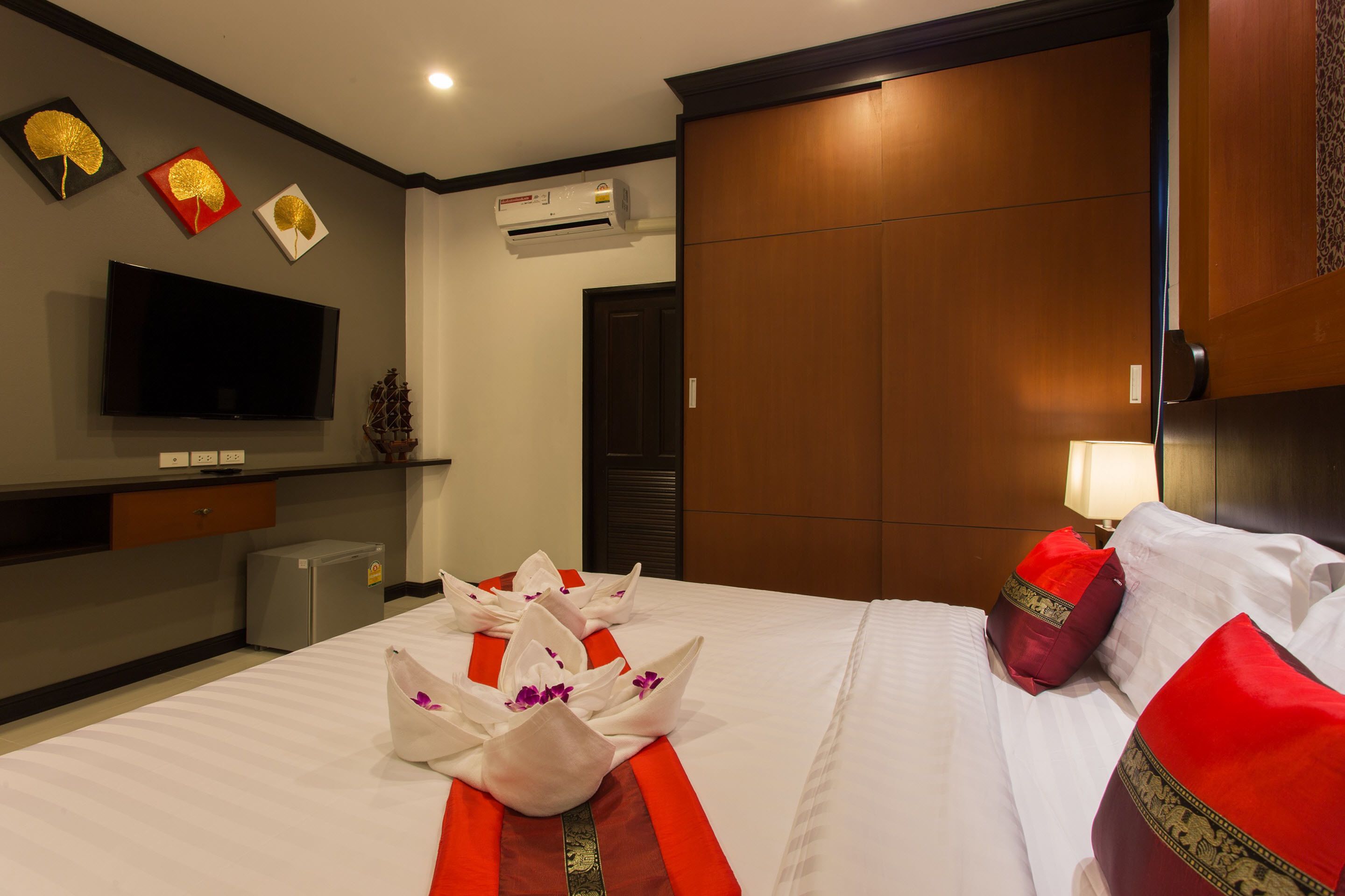 Una habitación de hotel con cama, televisión, minibar y armario.
