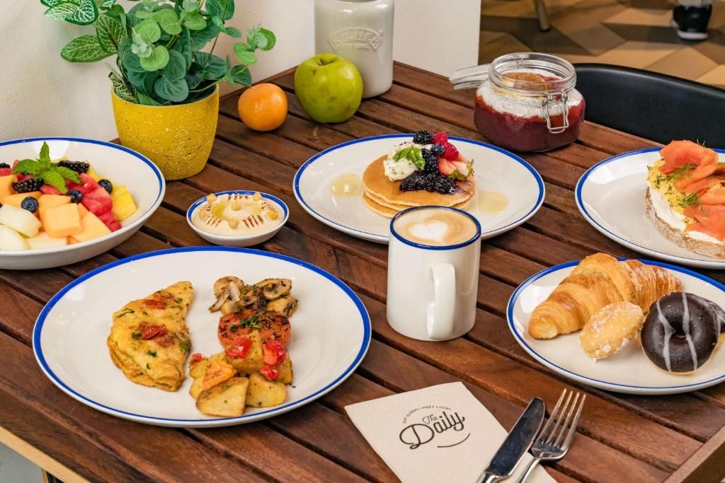 A breakfast table with plates of food, a coffee mug, and a menu.