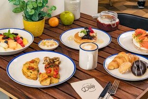A breakfast table with plates of food, a coffee mug, and a menu.