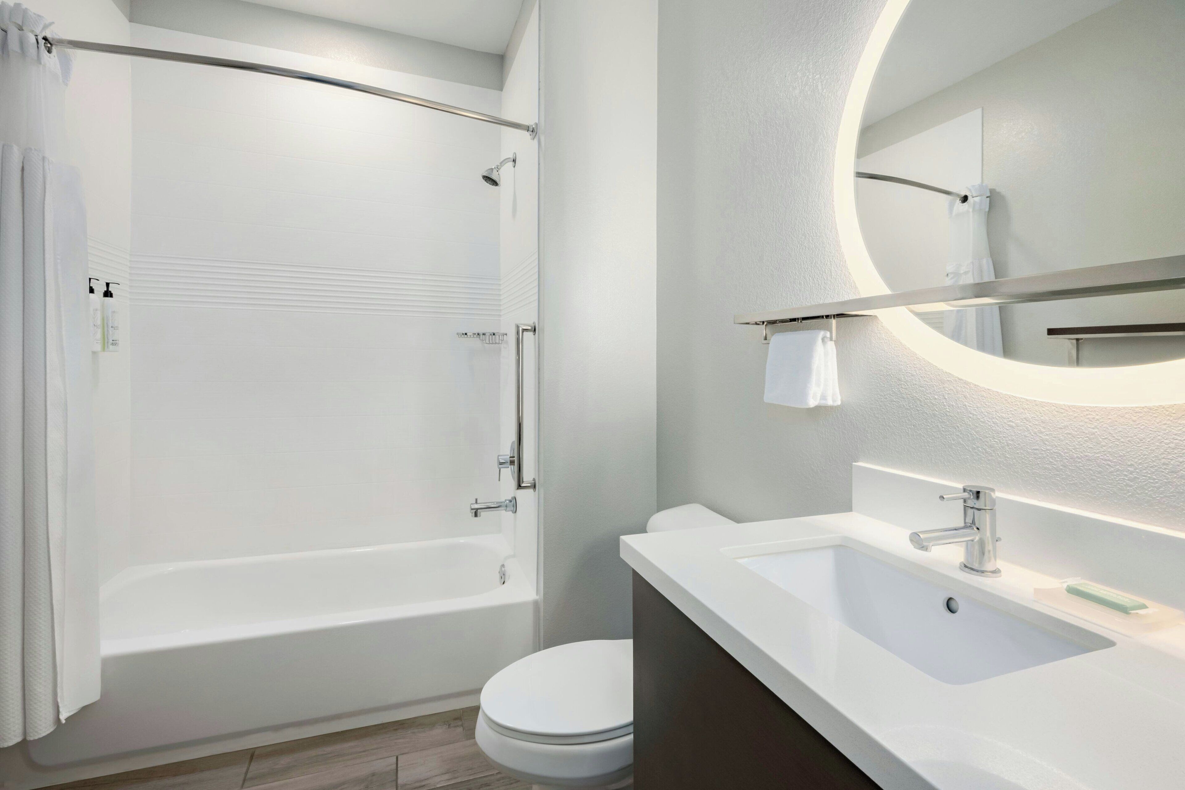 A modern bathroom with a bathtub, toilet, and sink.
