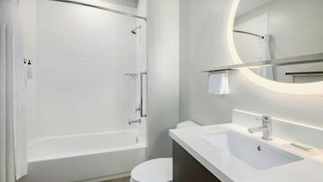 A modern bathroom with a bathtub, toilet, and sink.