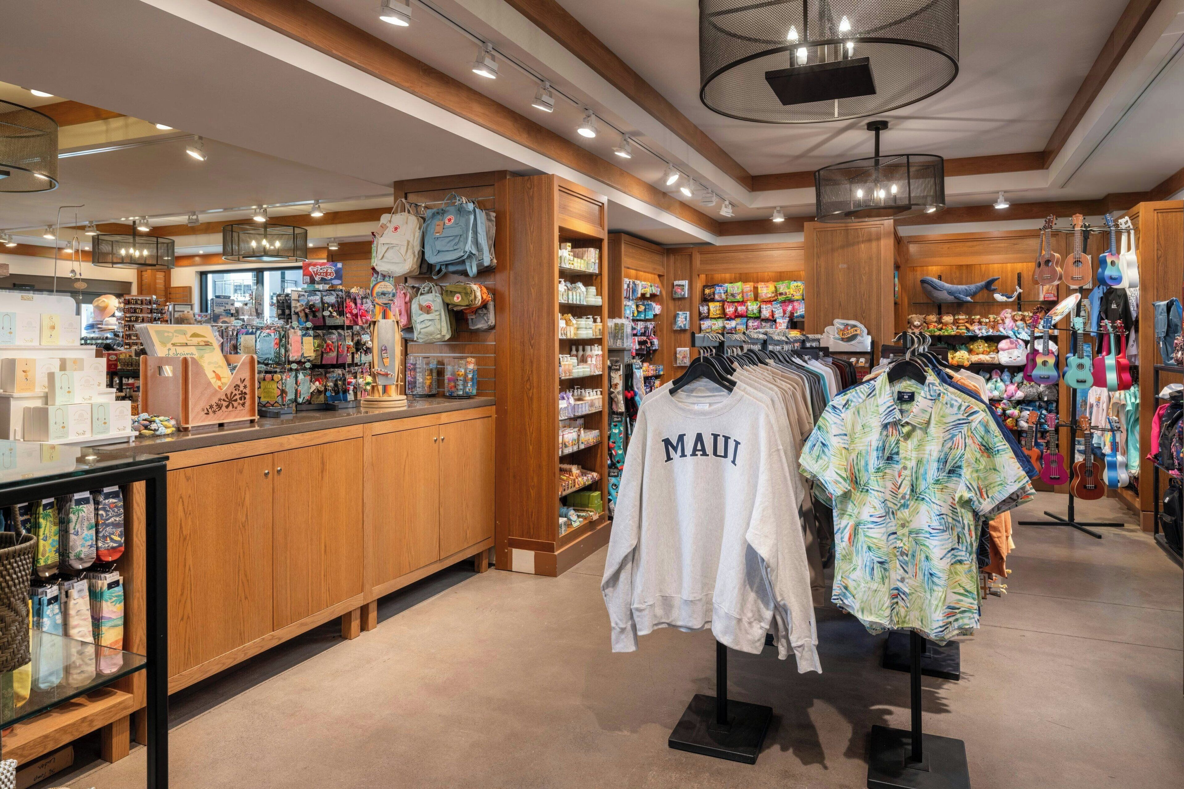 Un magasin de détail avec des étagères en bois, des portants à vêtements et divers produits exposés.