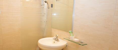 A bathroom with a toilet, sink, and shower area.