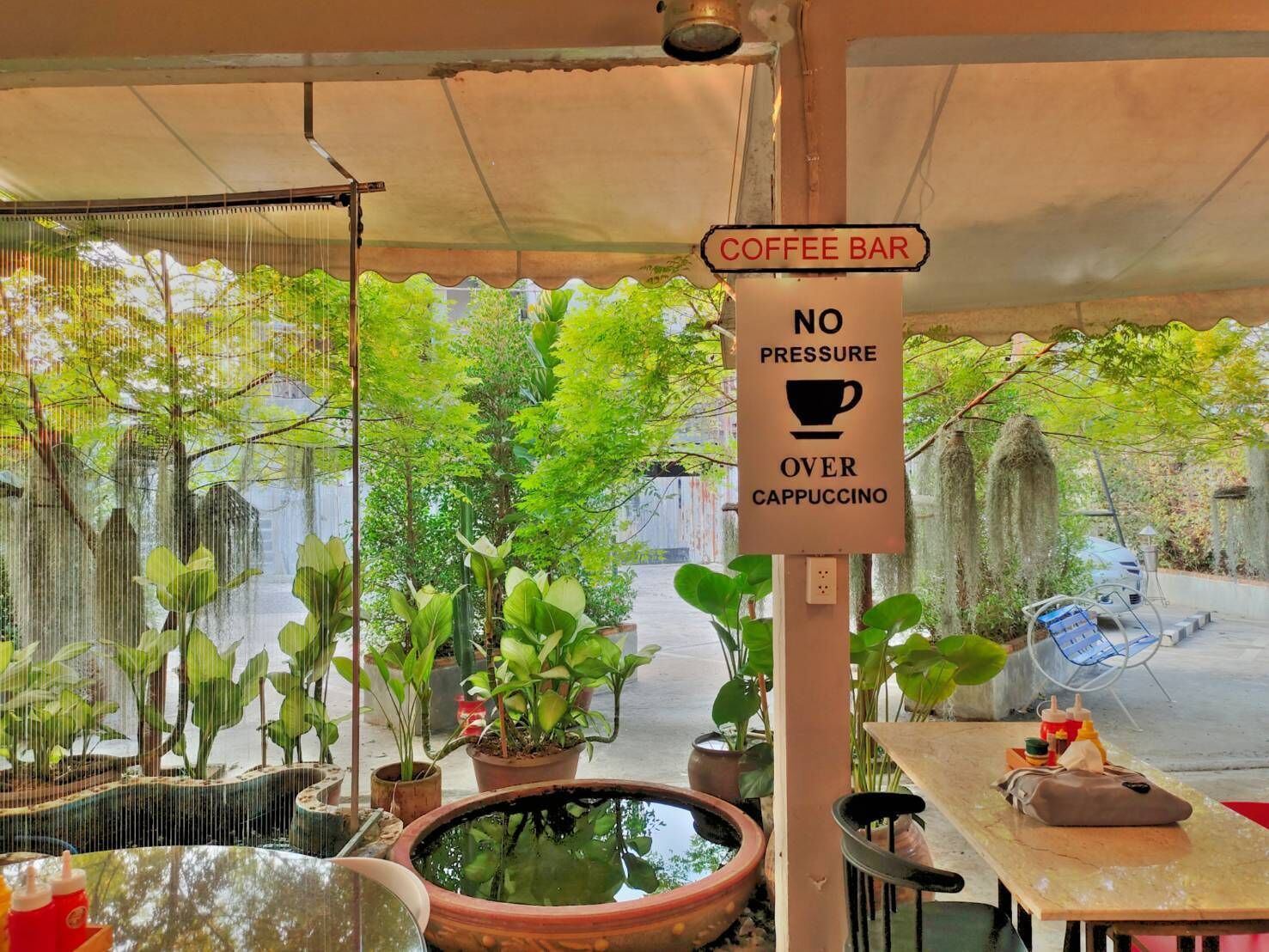 A coffee bar with a sign stating "NO PRESSURE OVER CAPPuccino".