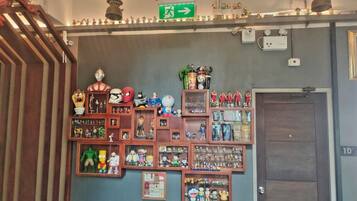 A wall with various collectibles and memorabilia, including action figures and figurines, arranged in shelves and boxes.