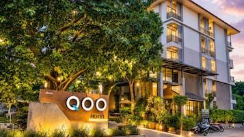 Un hotel con diseño moderno, un letrero y un jardín bien cuidado.