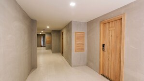 A corridor with wooden doors and a tiled floor. - B2 Buriram Boutique & Budget Hotel (Buriram)