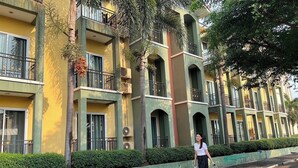 A multi-story hotel with balconies, large windows, and a green hedge in front. - B2 Buriram Boutique & Budget Hotel (Buriram)