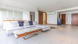 Una sala moderna con un sofá, una mesa de centro y un ventanal grande.