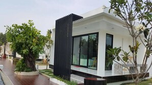 Un edificio moderno con techo plano, ventanas amplias y una estructura vertical negra.