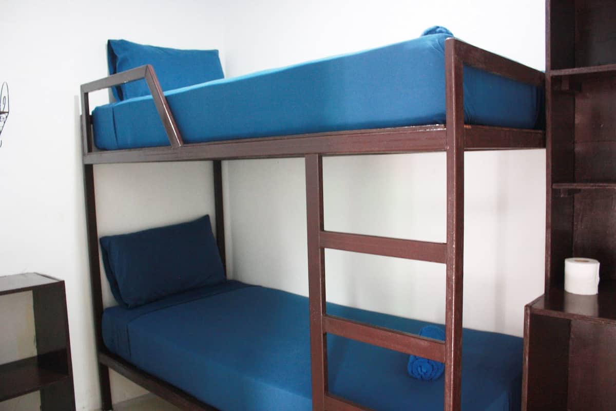 Un lit superposé avec une literie bleue et une structure en bois.