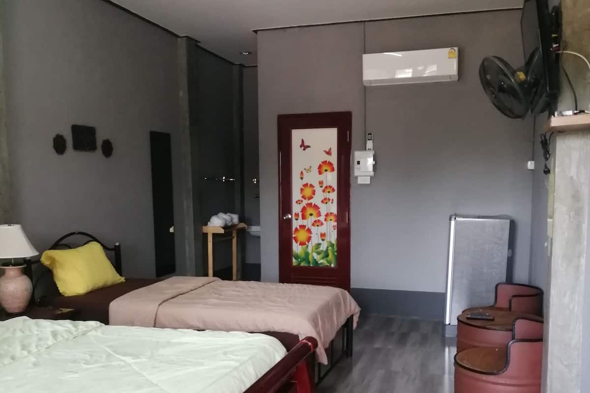 A bedroom with a bed, bedside tables, a chair, a small table, and a decorative door.